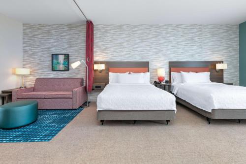 塔尔萨Home2 Suites By Hilton Tulsa Airport的酒店客房,配有两张床和椅子