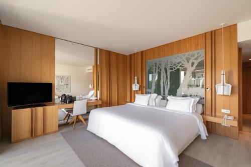 卡斯卡伊斯Onyria Marinha Boutique Hotel的卧室配有一张白色大床和一张书桌
