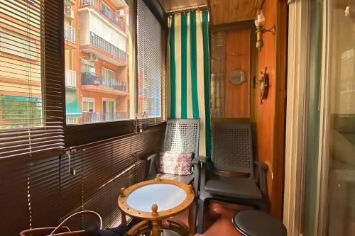 贝尼多姆Apartement "Brisa Marina" - 500 m from the beach的小阳台配有桌椅和窗户。