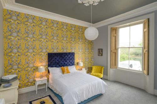 克利夫登Gorgeous Apartment Seconds from Seafront Clevedon的一间卧室配有床和黄色壁纸