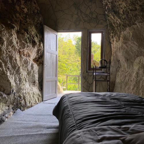 KarangwetanPALEO Stone Age的一间卧室配有一张床,一扇门设有窗户