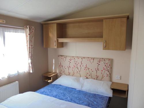 英戈尔德梅尔斯Seaview Ingoldmells Bromley 10 Berth 4 Bedrooms Central heated的一间小卧室,配有床和窗户