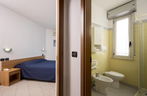 里米尼阿苏拉住宅别墅的浴室设有床、卫生间和水槽。