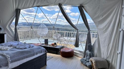 Dorna CîndrenilorDorna Iglu Luxury Glamping Resort的一间卧室设有一张床和一个大窗户