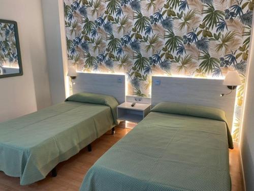 阿苏克卡德埃纳雷斯米拉尔坎波酒店的一间设有两张床和鲜花的墙壁的房间