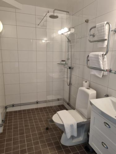 米约尔比Mjölby Stadshotell的带淋浴、卫生间和盥洗盆的浴室