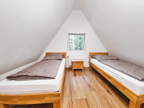 巴特阿罗尔森Ferienhaus 88的阁楼卧室设有两张床,配有窗户