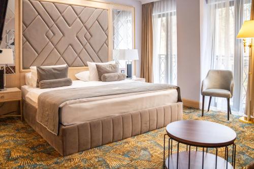 弗尔尼亚奇卡矿泉镇A Hoteli - Hotel Park的一间卧室配有一张大床和一张桌子及椅子