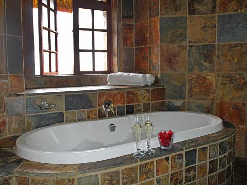 HekpoortSable Mountain的浴室设有浴缸,配有2个酒杯
