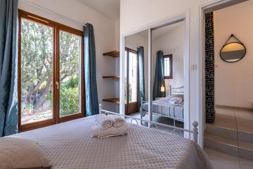 利勒鲁斯Villa Bollaccia - Vue mer avec piscine的一间卧室配有一张床和一面大镜子