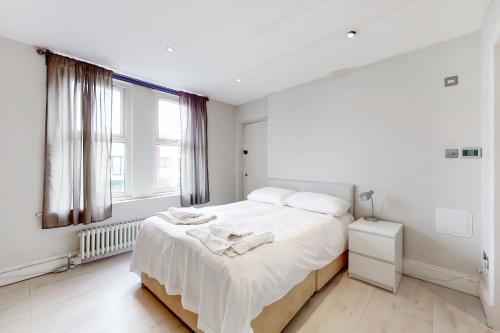 伦敦Modern 3 Bed Apartment in Hampstead的白色的卧室设有床和窗户