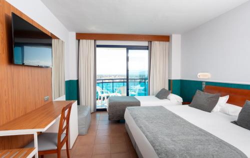 甘迪亚西贝莱斯海滩酒店的酒店客房配有两张床和一张书桌