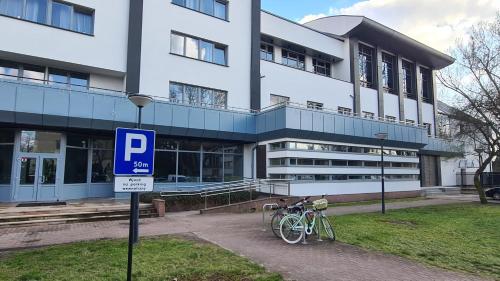 华沙CKS Warszawa (Centrum Konferencyjno-Szkoleniowe CS Natura Tour)的停放在大楼前的两辆自行车