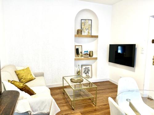 罗莫朗坦Les Logis d'Esmeralda-Des appartements au charme intemporel的客厅配有白色沙发和电视