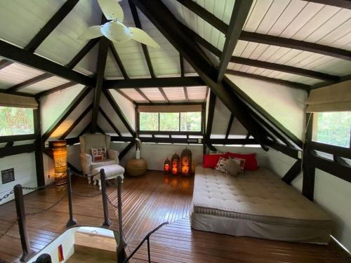 佩尼多Dingo - Refugio romântico em meio à natureza的阁楼间设有一张床和一个吊扇。