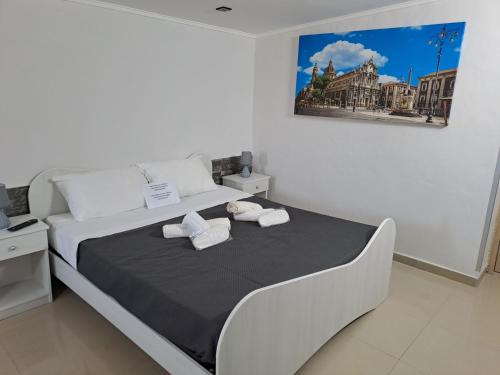卡塔尼亚House il Quadrifoglio Airport Fontanarossa的一间卧室配有一张床,上面有两条毛巾