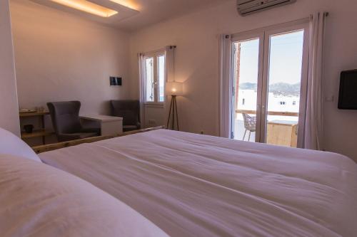 阿波罗尼亚SALT SUITES MILOS的卧室设有一张白色大床和一扇窗户。