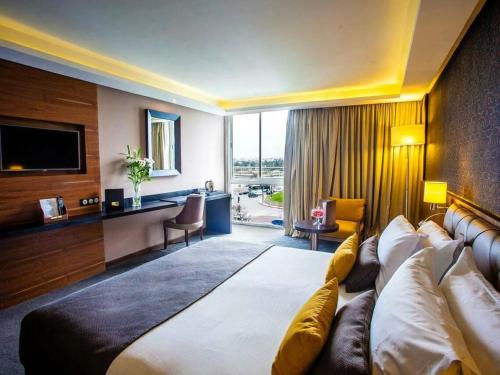 拉巴特Hotel Rabat - A member of Barceló Hotel Group的一间配备有沙发及电视的酒店客房