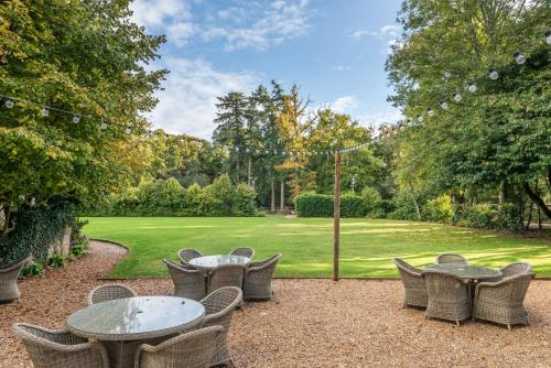 伯利Moorhill House Bed & Breakfast的一个带桌椅的庭院和一个草坪