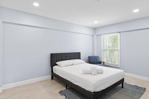 萨尼贝尔Upgraded Ground Floor Residence on Buttonwood Ln w Bikes的白色卧室配有床和蓝椅