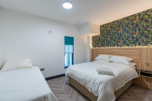 伦敦德里Hotel No.9的一间卧室配有两张床和壁画