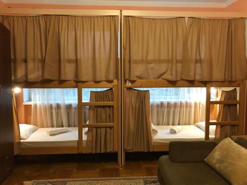 切尔诺夫策Pelican Guest House & Hostel的带沙发的客房内的两张双层床
