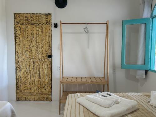 阿拉亚尔达茹达Vila Rita Hostel Arraial d'Ajuda的一间设有木门的房间,床上配有毛巾