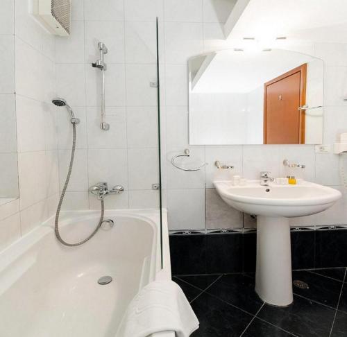 奥格斯堡Hotel Pension Matteo的白色的浴室设有水槽、浴缸和水槽。