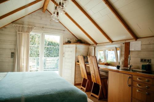 特镇L'Escale Zen - Tiny House (Jacuzzi/Sauna)的一间卧室配有一张床和一张书桌