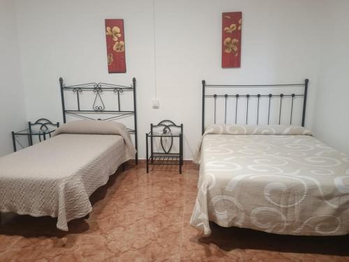格拉纳达ROOMS Los MONTES的一间卧室设有两张床和两张边桌