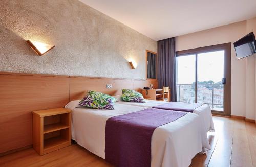 罗列特海岸桑巴酒店的酒店客房设有两张床和窗户。