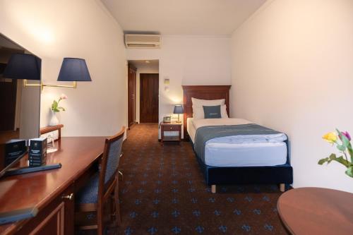维也纳Select Hotel Prinz Eugen Wien的配有一张床和一张书桌的酒店客房