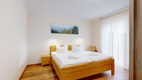 宾茨Residenz Margarete的一间卧室配有一张带白色床单的床和一扇窗户。