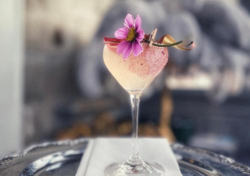 耶尔费拉约尔文斯城堡酒店的一杯粉红色的饮料,玻璃上装有紫色花