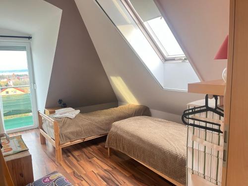 巴拉顿菲赖德Balatonfüred Apartment的阁楼卧室设有两张床和窗户。