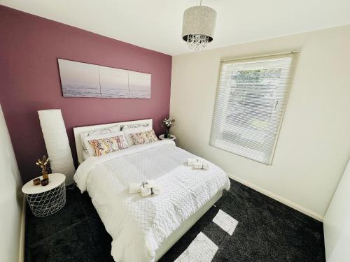 KnightswoodGlasgow Modern style home , separate entrance的卧室配有白色的床和紫色墙壁