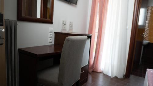 卡兰巴卡Rooms Batalogianni的窗户客房内的桌椅