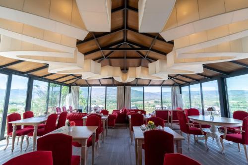 托里迪蒙科尔武昆塔达特林查乡间别墅酒店的餐厅设有红色的桌椅和大吊灯。