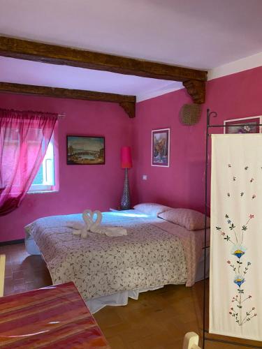 博马尔佐Il nido的卧室配有一张带粉红色墙壁的大床