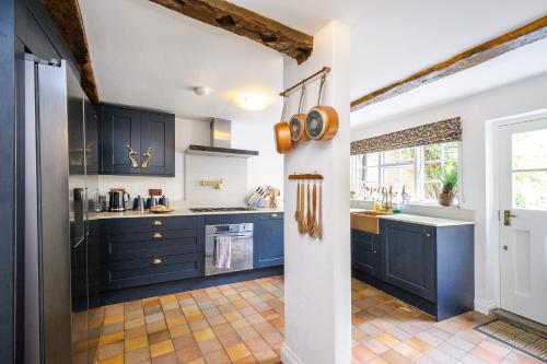 萨弗伦沃尔登Contractors Deluxe Essex Short Stay House的厨房配有蓝色橱柜和水槽