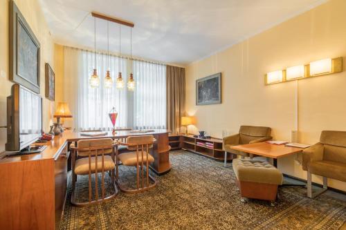 莱比锡莱比锡伽勒瑞尔酒店的酒店客房设有带桌椅的等候区。