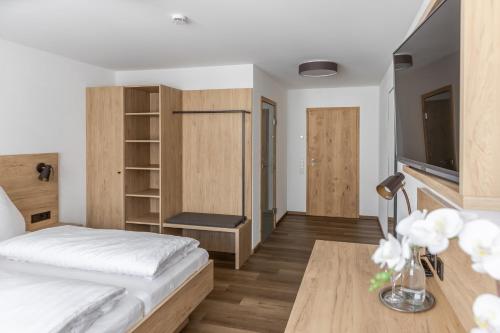 Gasthof Zum Roten Haus的一间卧室配有一张床和一张书桌及电视