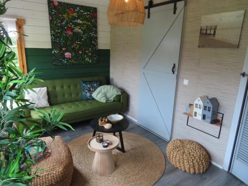 曲马勒姆Tiny Botanic House的客厅配有绿色沙发和桌子