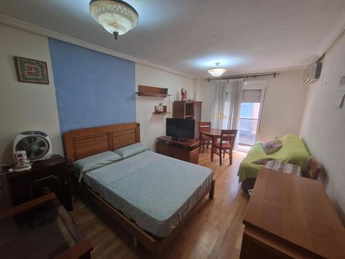 阿利坎特Casa Linda的卧室配有1张床、1张桌子和1把椅子