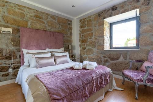 托里迪蒙科尔武昆塔达特林查乡间别墅酒店的一间卧室设有一张床和石墙
