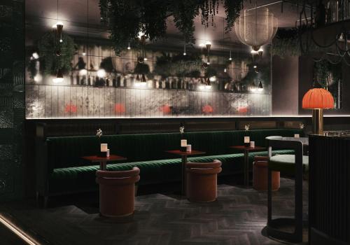 萨尔茨堡Gentle Hide Designhotel的一间设有绿色座椅的餐厅和一间酒吧