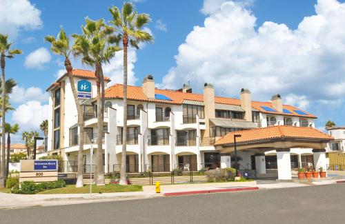 亨廷顿海滩亨廷顿海滩酒店的一座白色的大建筑,前面有棕榈树