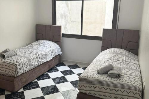 丹吉尔Beautiful Sea View Apartment in Tangier的卧室内的两张床,铺有 ⁇ 木地板