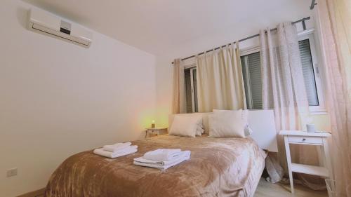 AglantziaSTAY Tranquil Terrace的一间卧室配有一张床,上面有两条毛巾