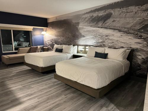 尼亚加拉瀑布Cambria Hotel Niagara Falls的酒店客房,设有两张床和一张沙发